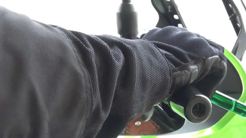 In extreme close-up, the Passage Gloves are wrapped firmly around the controls of a bike.