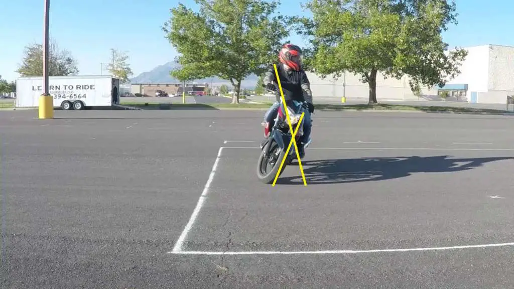 Rider counterweighting with shoulders leaned out opposite the bike