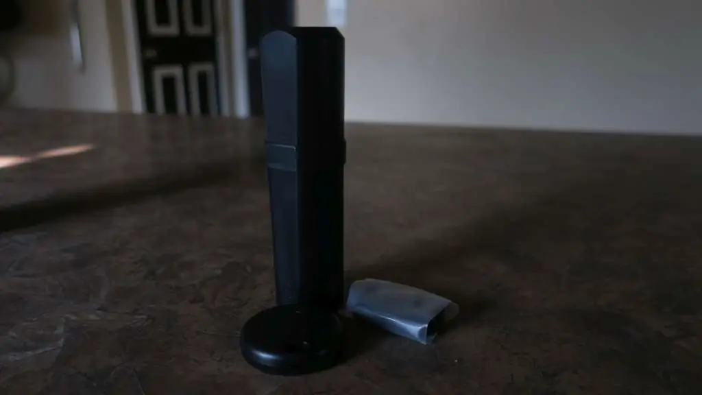 Pictured is the Monimoto device unboxed. The transponder is a cylinder, roughly 5" long and 1.5" in diameter. The key fob is a circle roughly 1.5" in diameter. Also pictured is a cellophane envelope containing two heavy-duty zip ties.